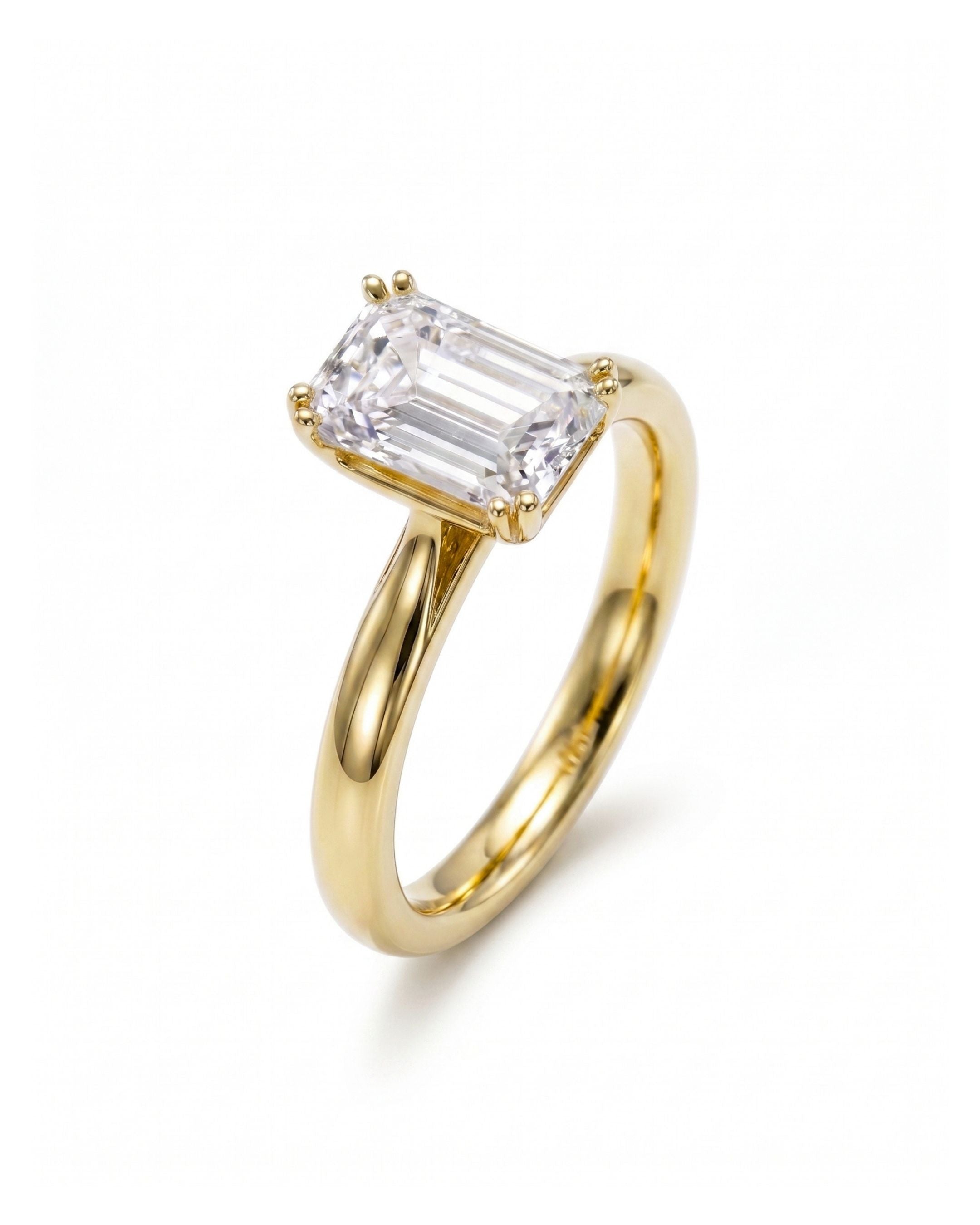 Yellow gold engagement ring with an emerald cut diamond.
