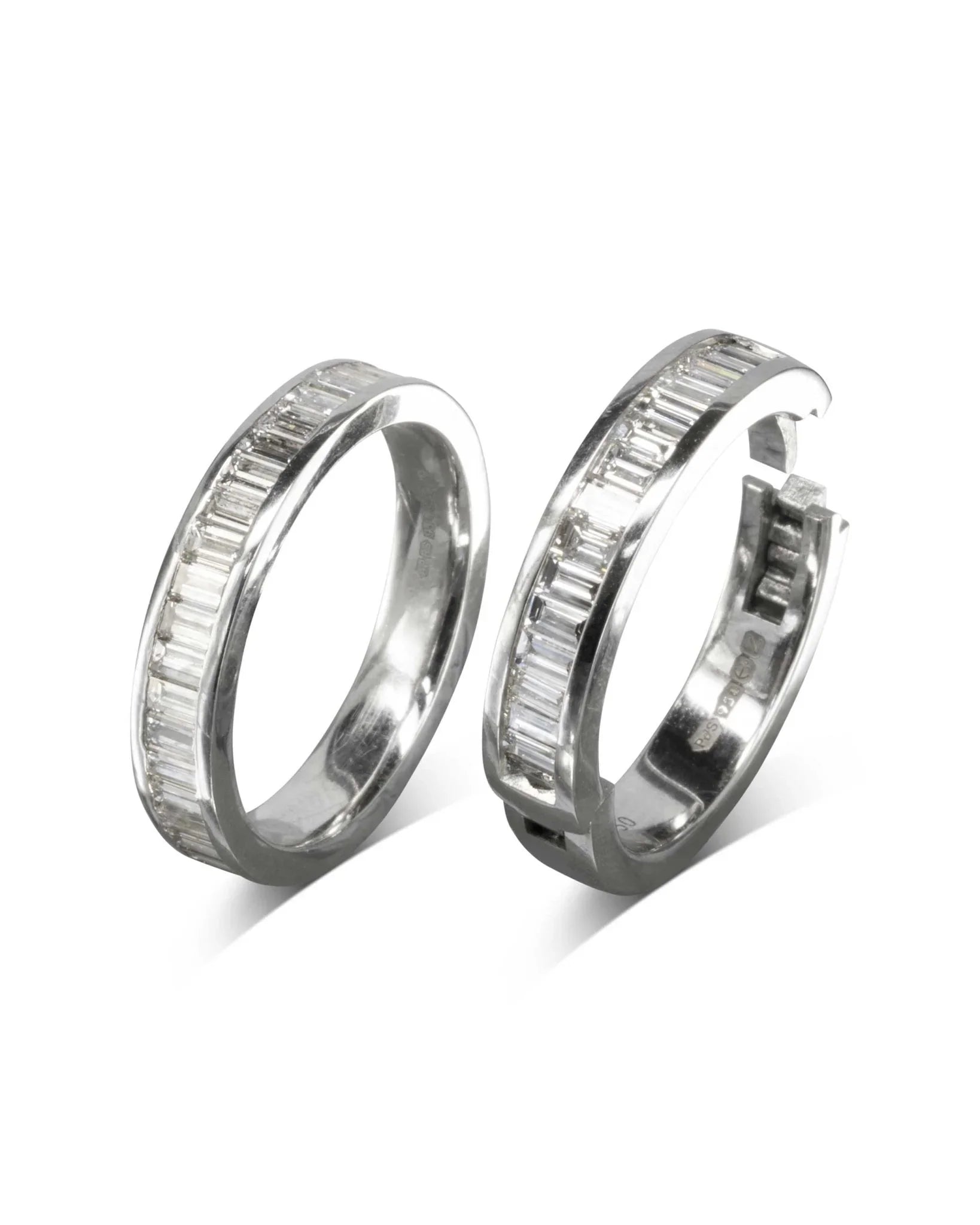 Platinum eternity ring with baguette diamonds, one hinged open.