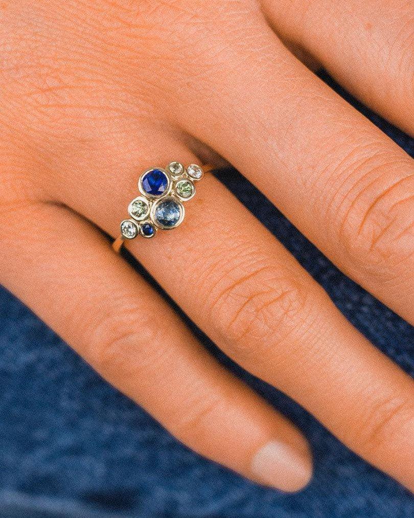 Platinum cluster ring with sapphire and diamond gemstones on hand