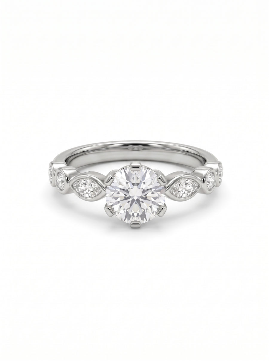 Round cut diamond engagement ring in silver metal with marquise and round side stones on a white background.