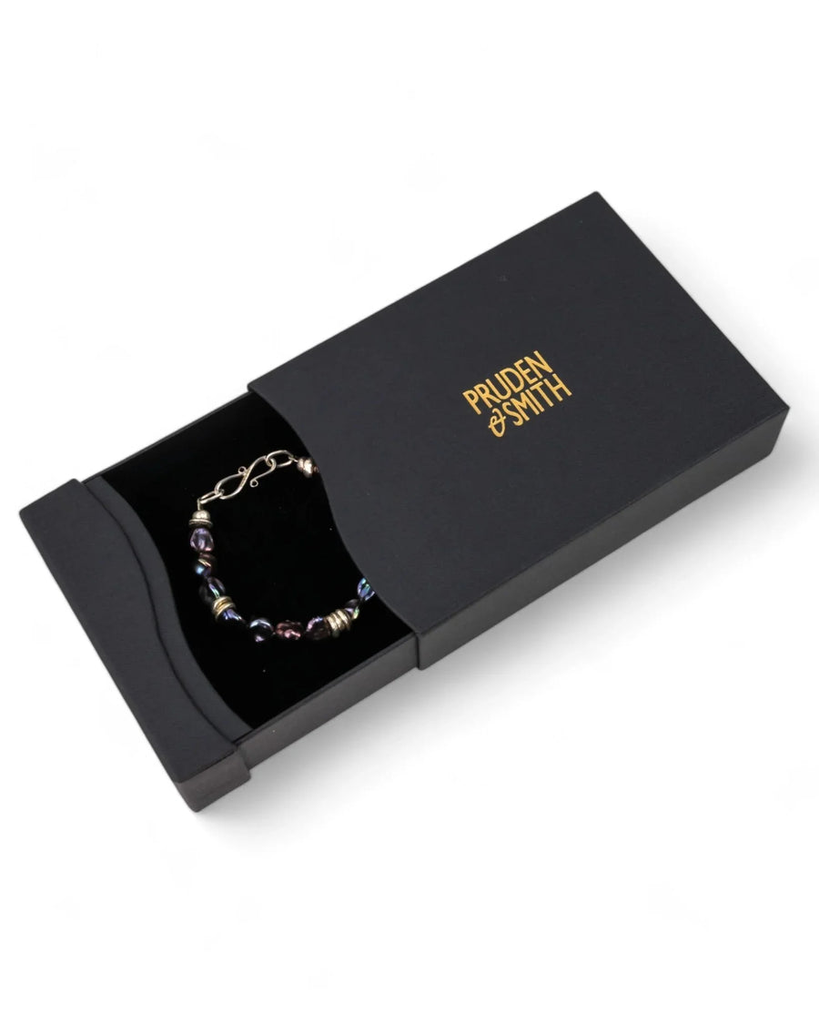 Black keshi pearl and silver bracelet in a matte black gift box on white background