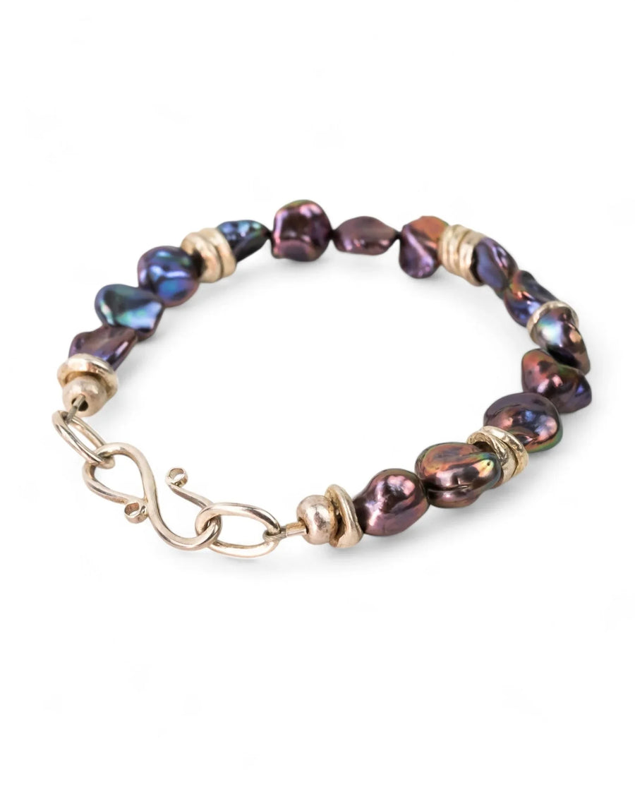 Black keshi pearl bracelet with silver beads and organic shapes on white background