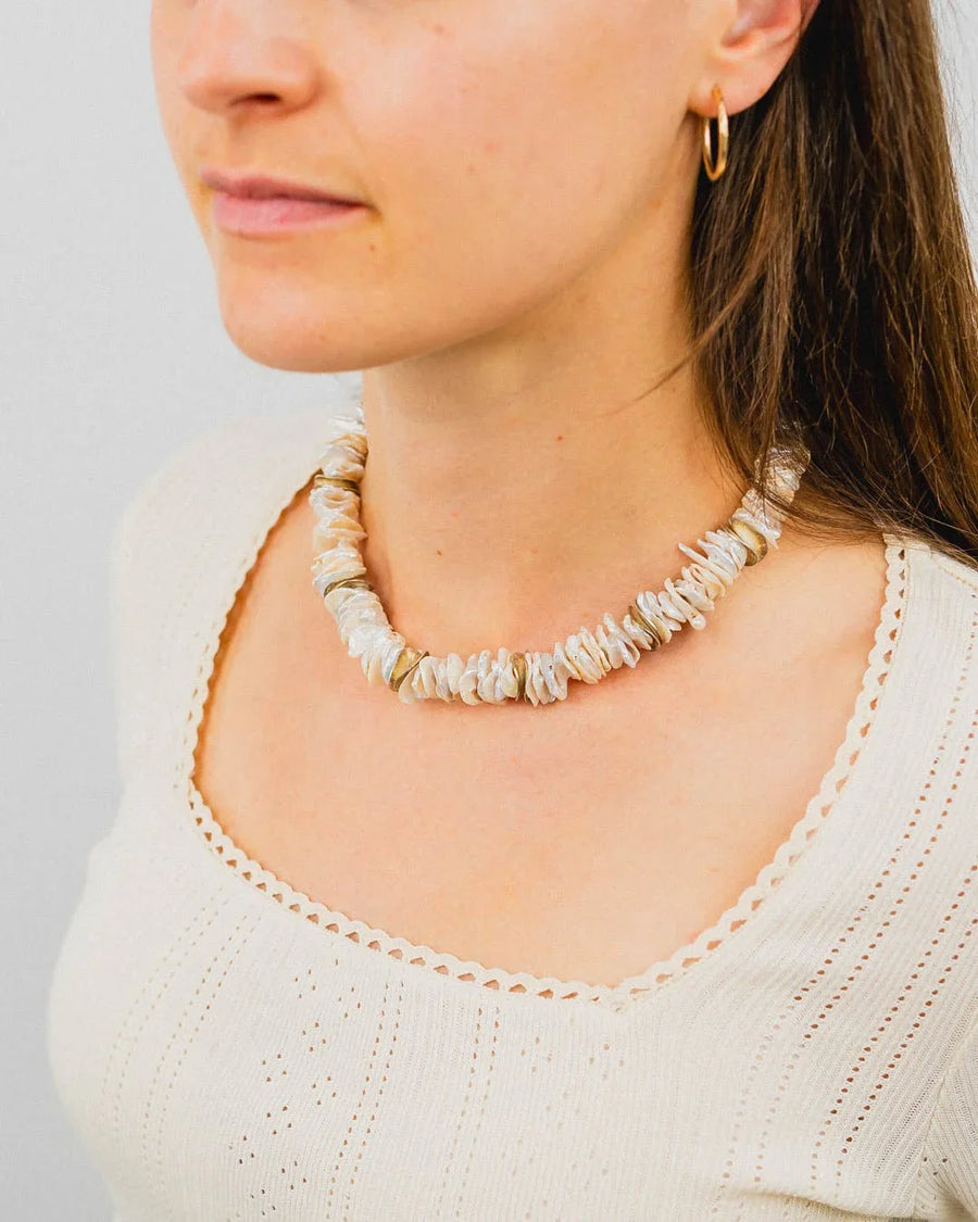 Keshi pearl and silver disc necklace with irregular white pearls and gold accents.