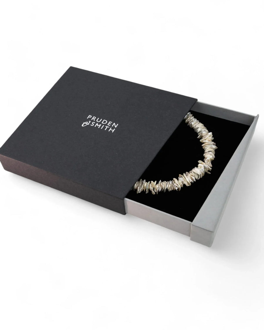 Keshi pearl and silver disc necklace in a black gift box.