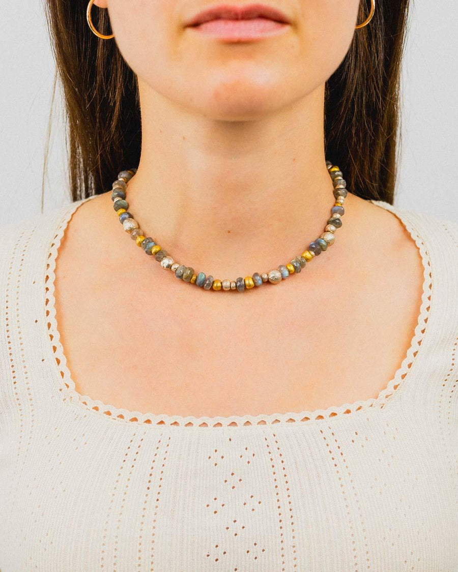 Labradorite silver and gold nugget necklace on woman wearing cream top