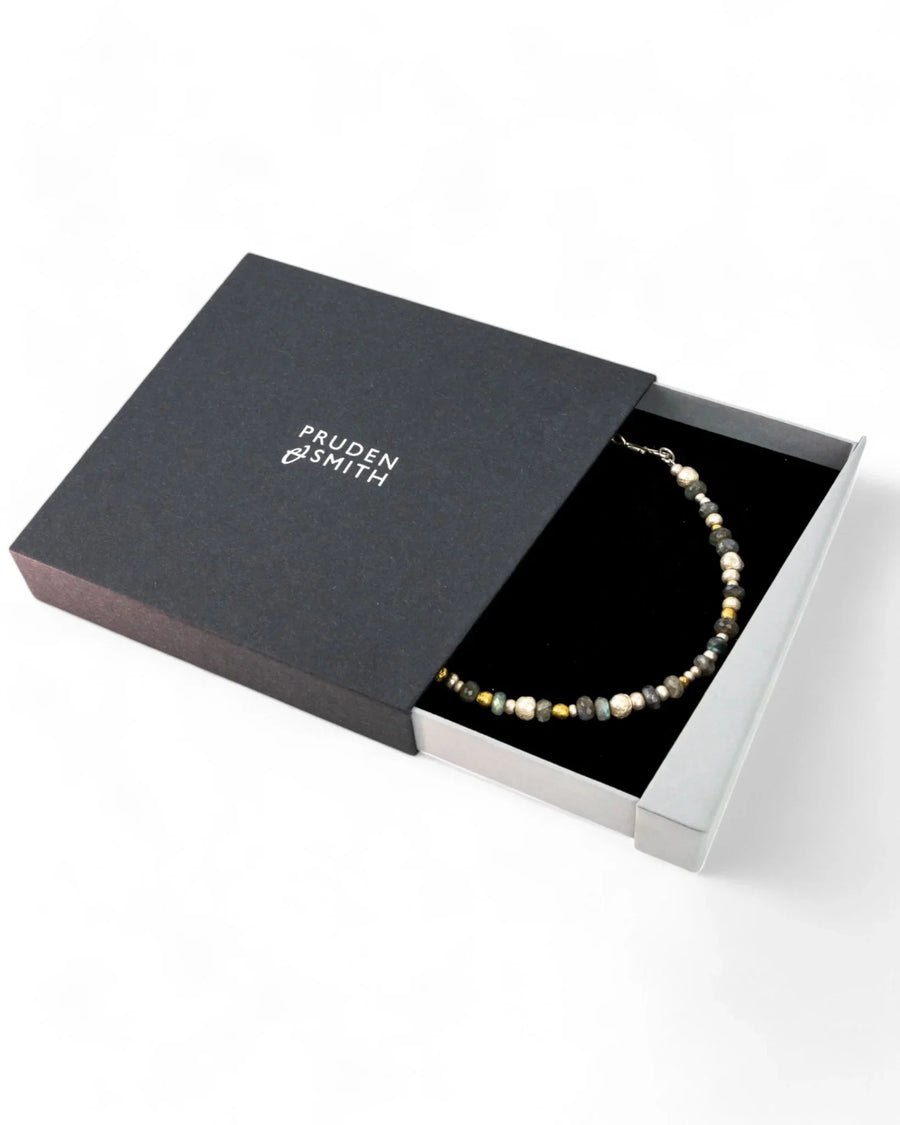 Labradorite silver and gold nugget necklace displayed in a black jewelry box