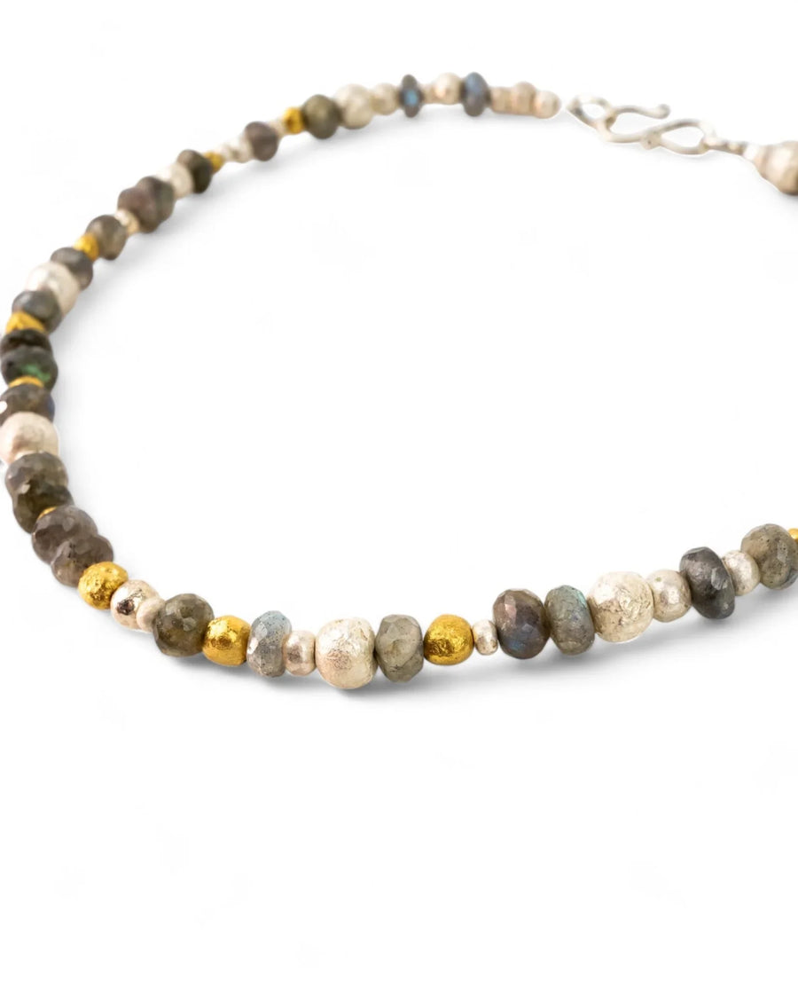 Handmade necklace with labradorite, silver, and gold nugget beads on white background