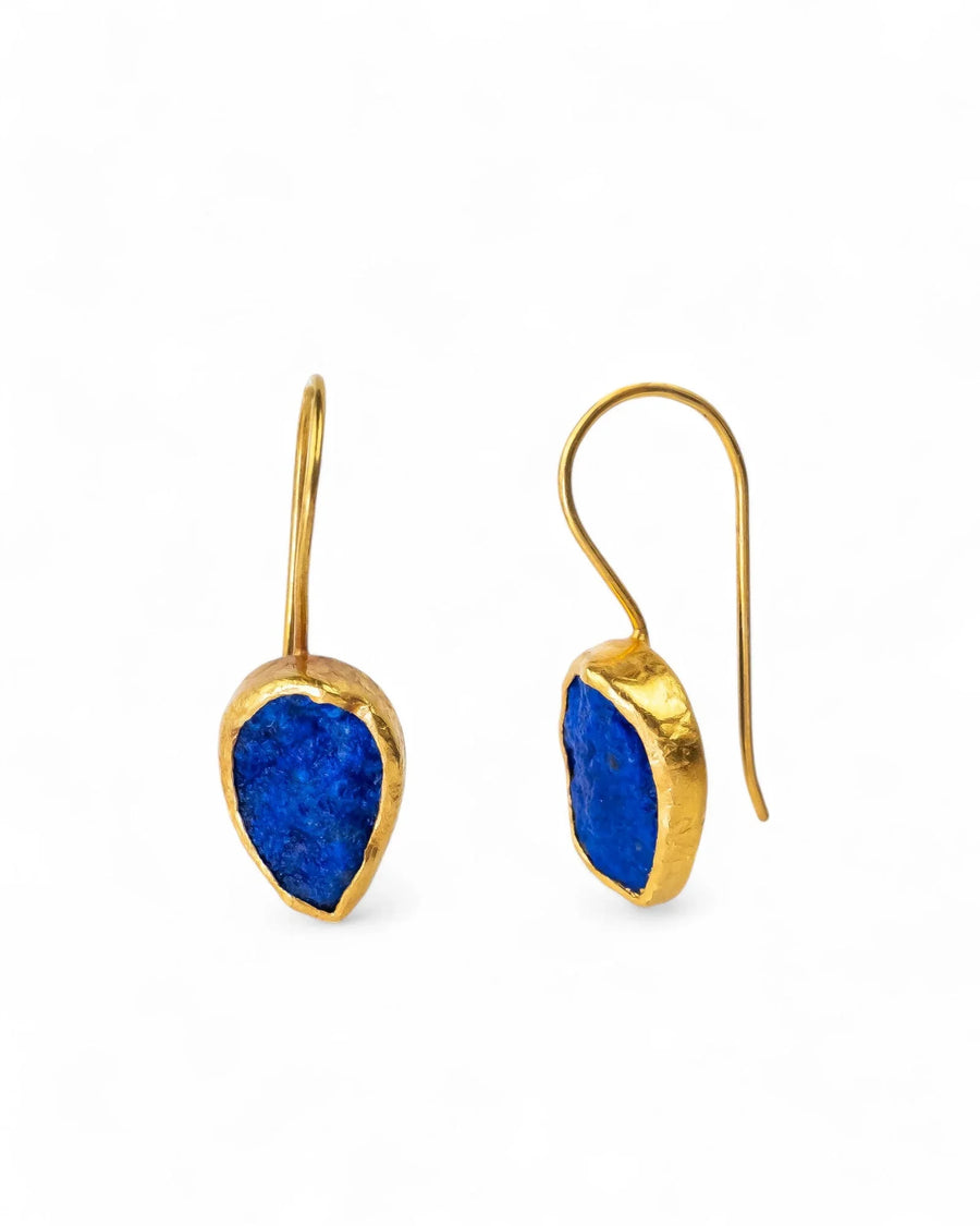 Gold drop earrings with raw lapis lazuli stones, organic shape, on white background