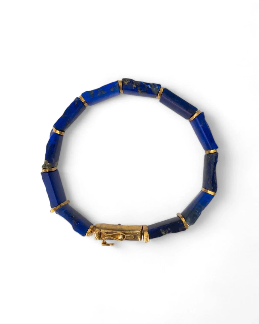 Handmade gold bracelet with natural lapis lazuli stones on white background