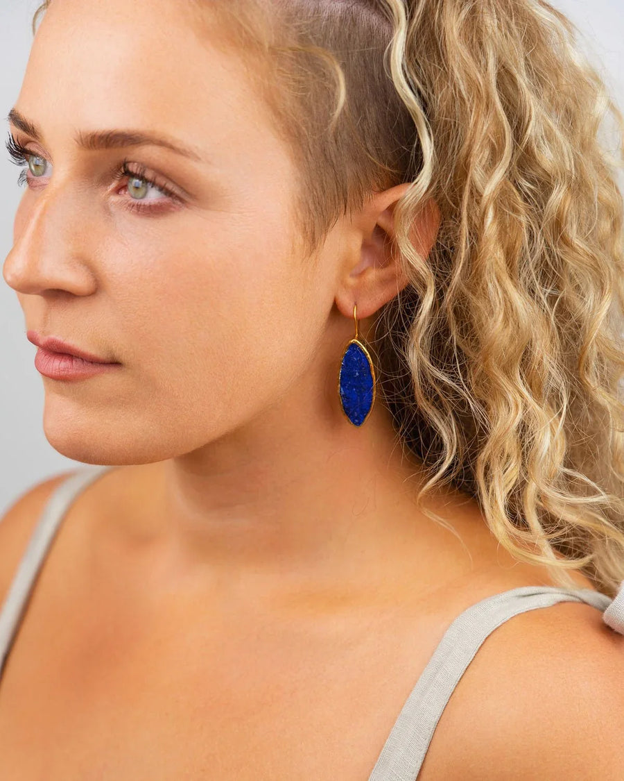 Woman wearing marquise-shaped lapis lazuli drop earring with gold setting