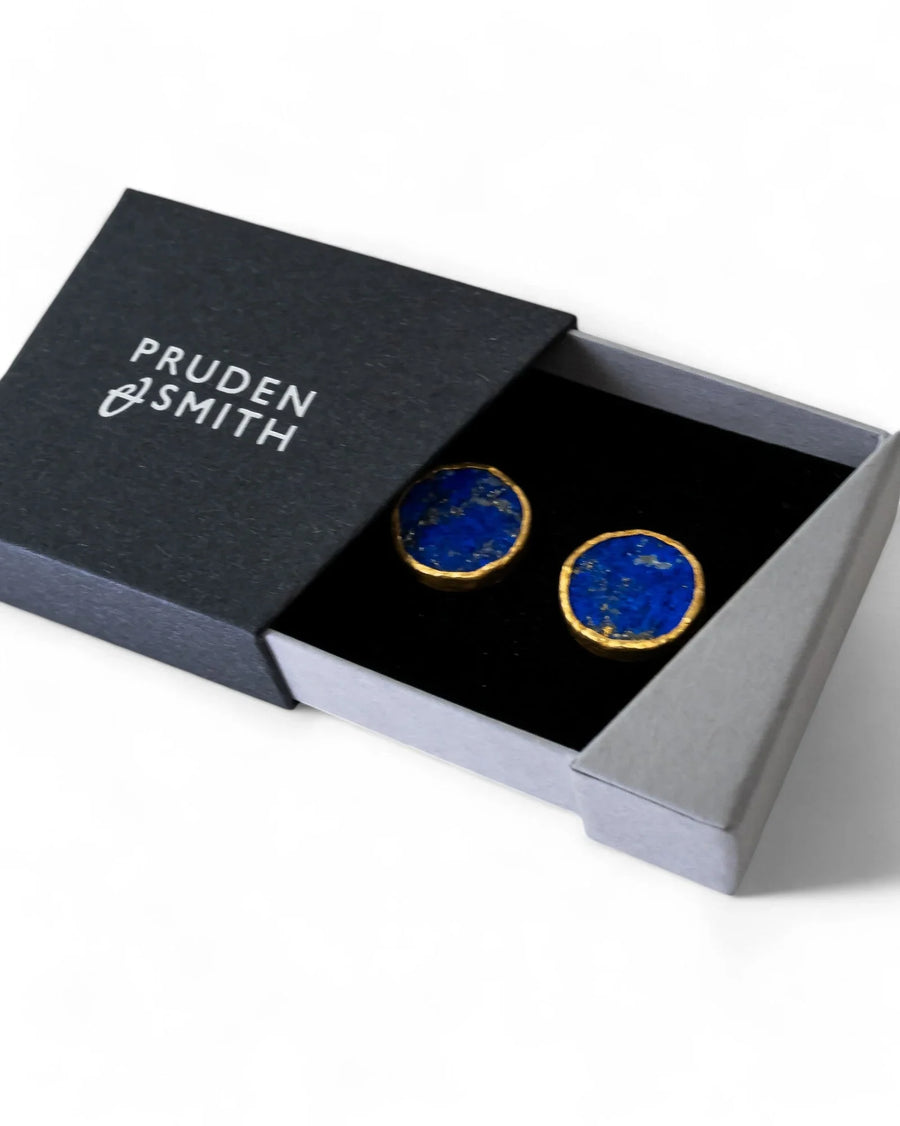 Pair of round lapis lazuli stud earrings with silver and gold edging in a gift box