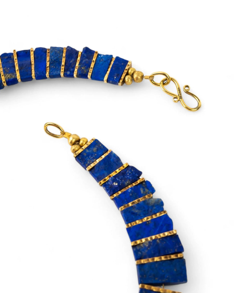 Lapis lazuli tab necklace with textured gold spacers and clasp on white background