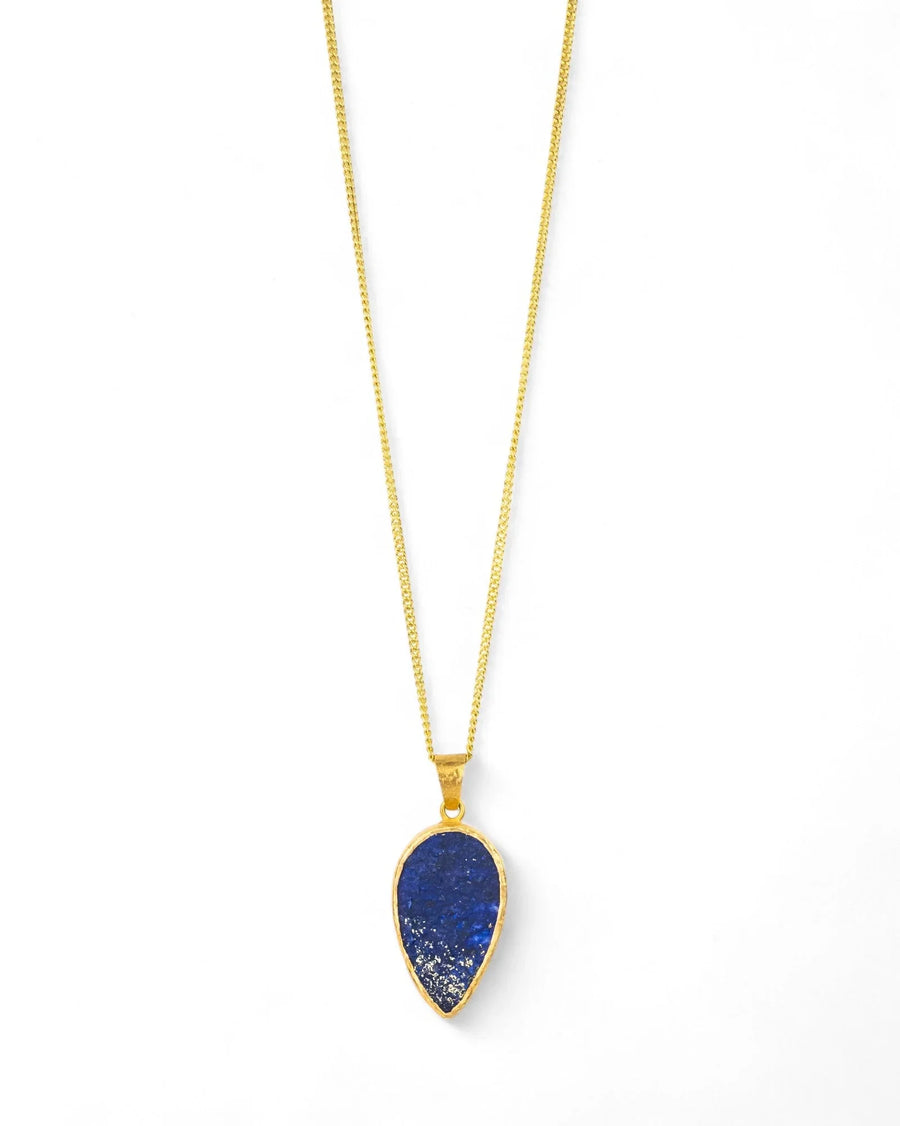 Lapis lazuli teardrop pendant in yellow gold on a chain, minimalist background