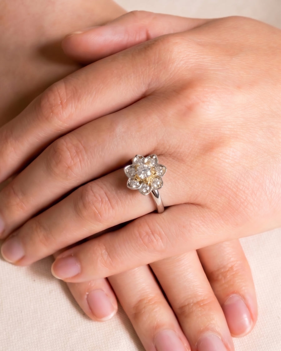 Silver ring with a lotus flower cluster of diamonds and yellow gemstones.