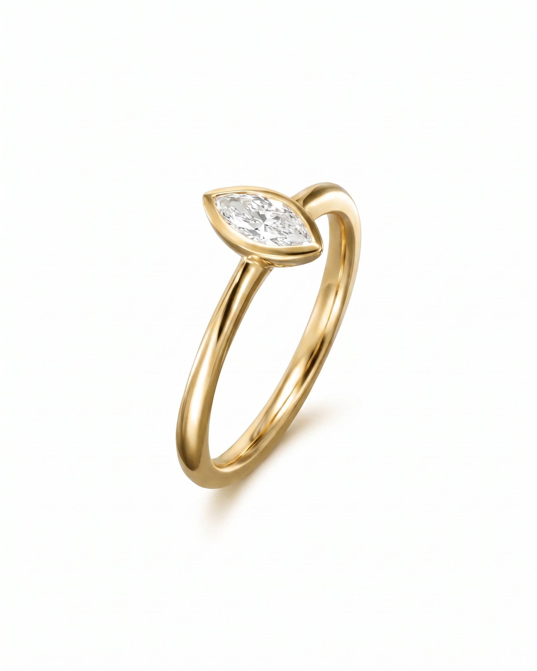 Gold engagement ring with a marquise cut diamond in a bezel setting.