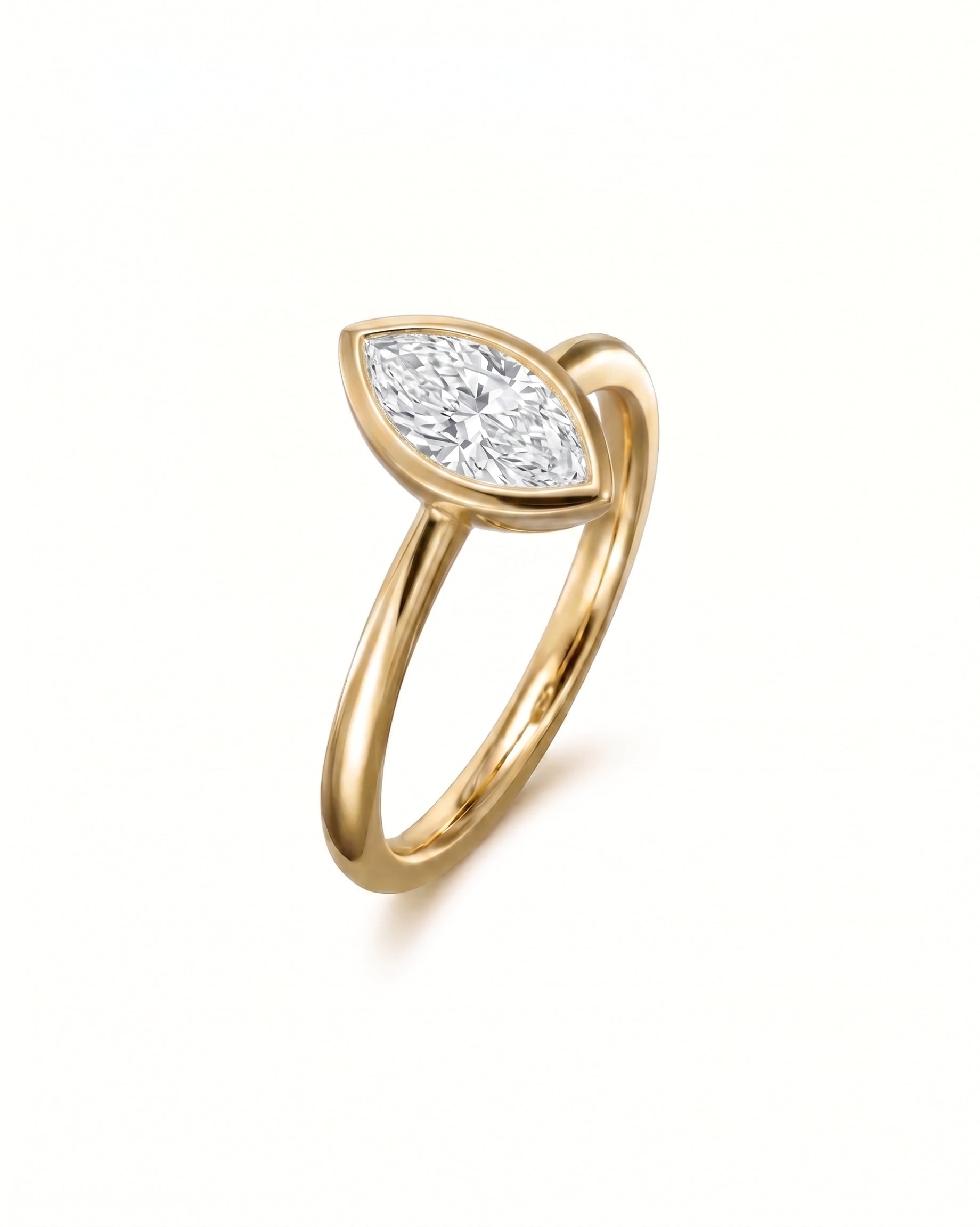 Gold engagement ring with a marquise cut diamond in a bezel setting.
