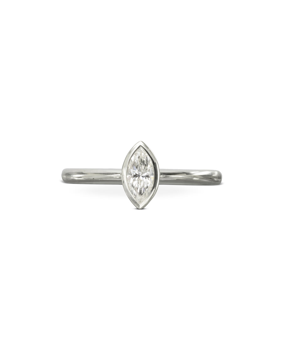 Silver engagement ring with a marquise cut diamond in a bezel setting.