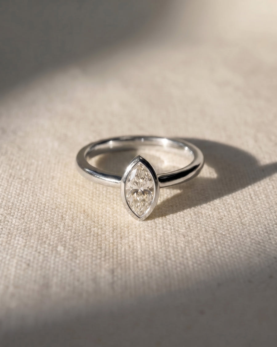 Platinum marquise cut lab-grown diamond bezel engagement ring.