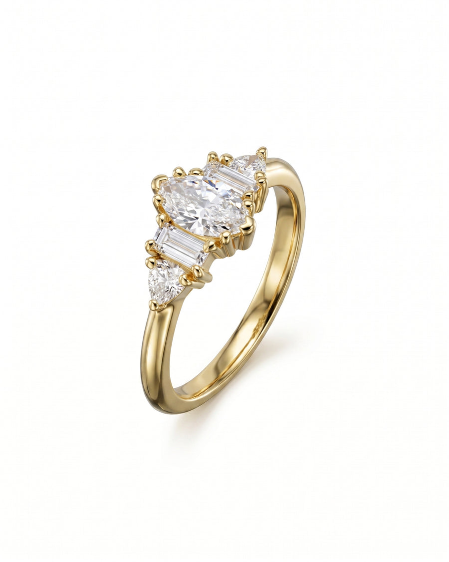 Gold engagement ring with a marquise diamond center, flanked by baguette and pear side stones.