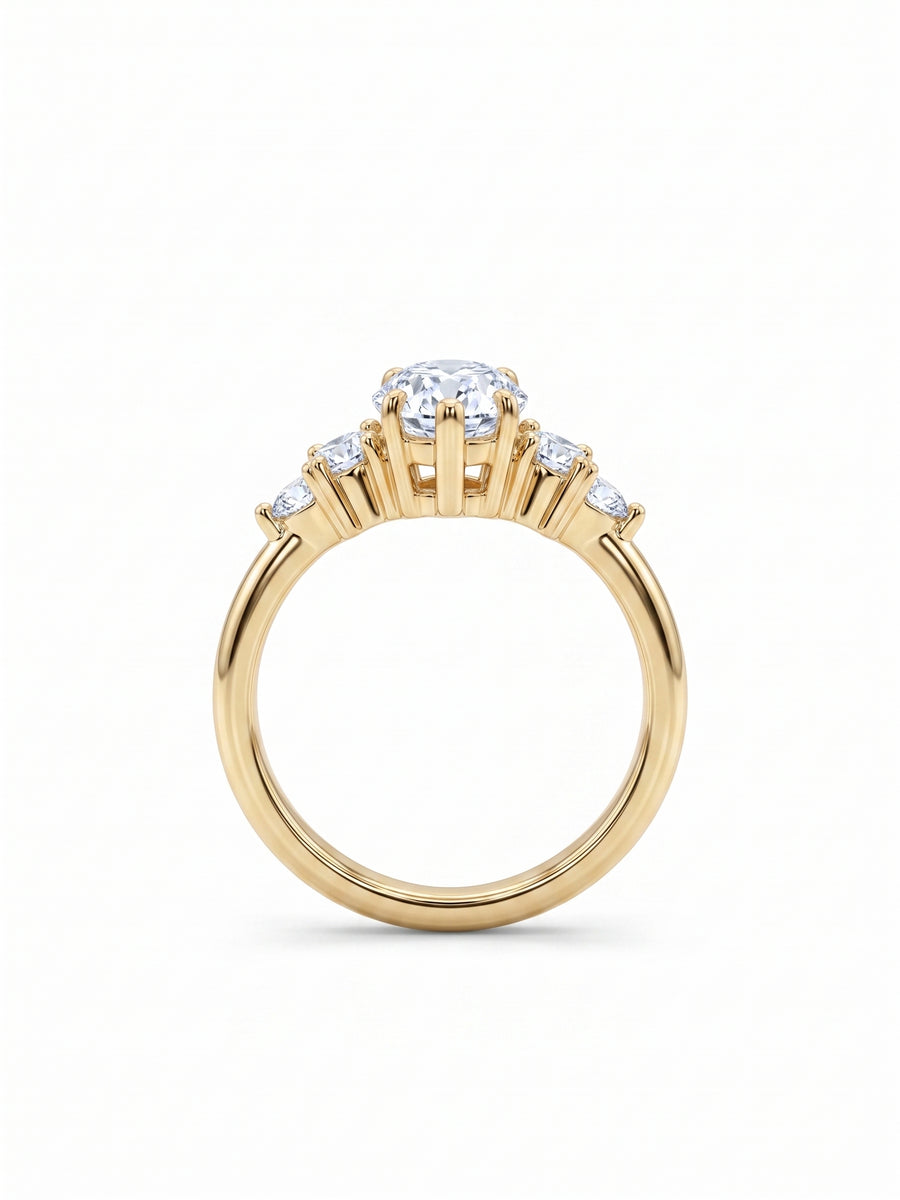 Yellow gold engagement ring with a central marquise cut diamond and small round side stones in claw settings.