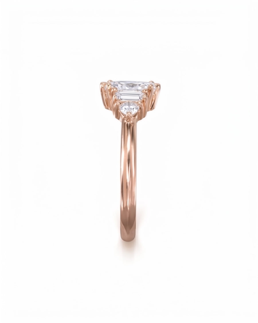 Rose gold engagement ring featuring a marquise center stone with baguette and round side diamonds.