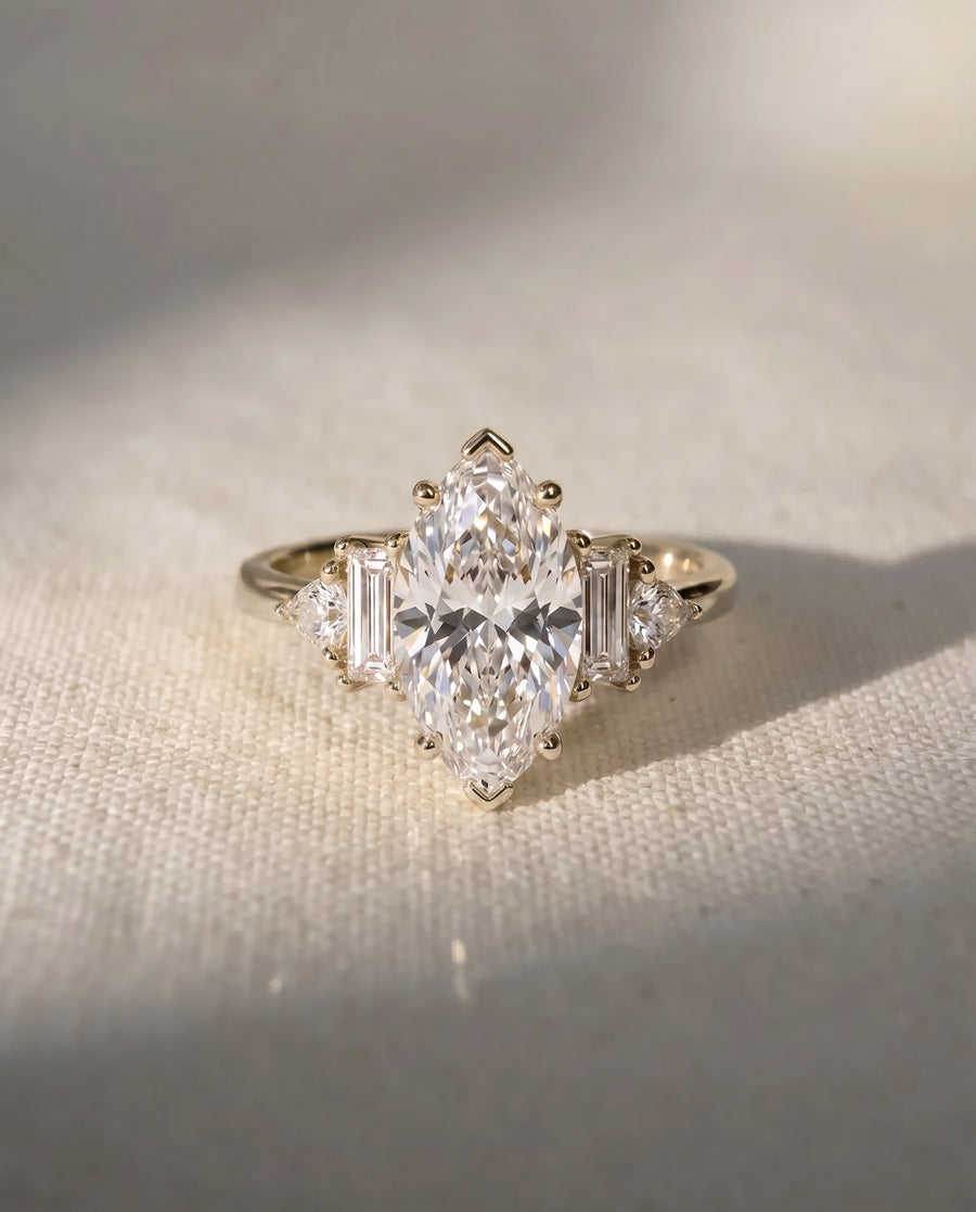 9ct white gold engagement ring with a marquise cut center stone and baguette side stones.