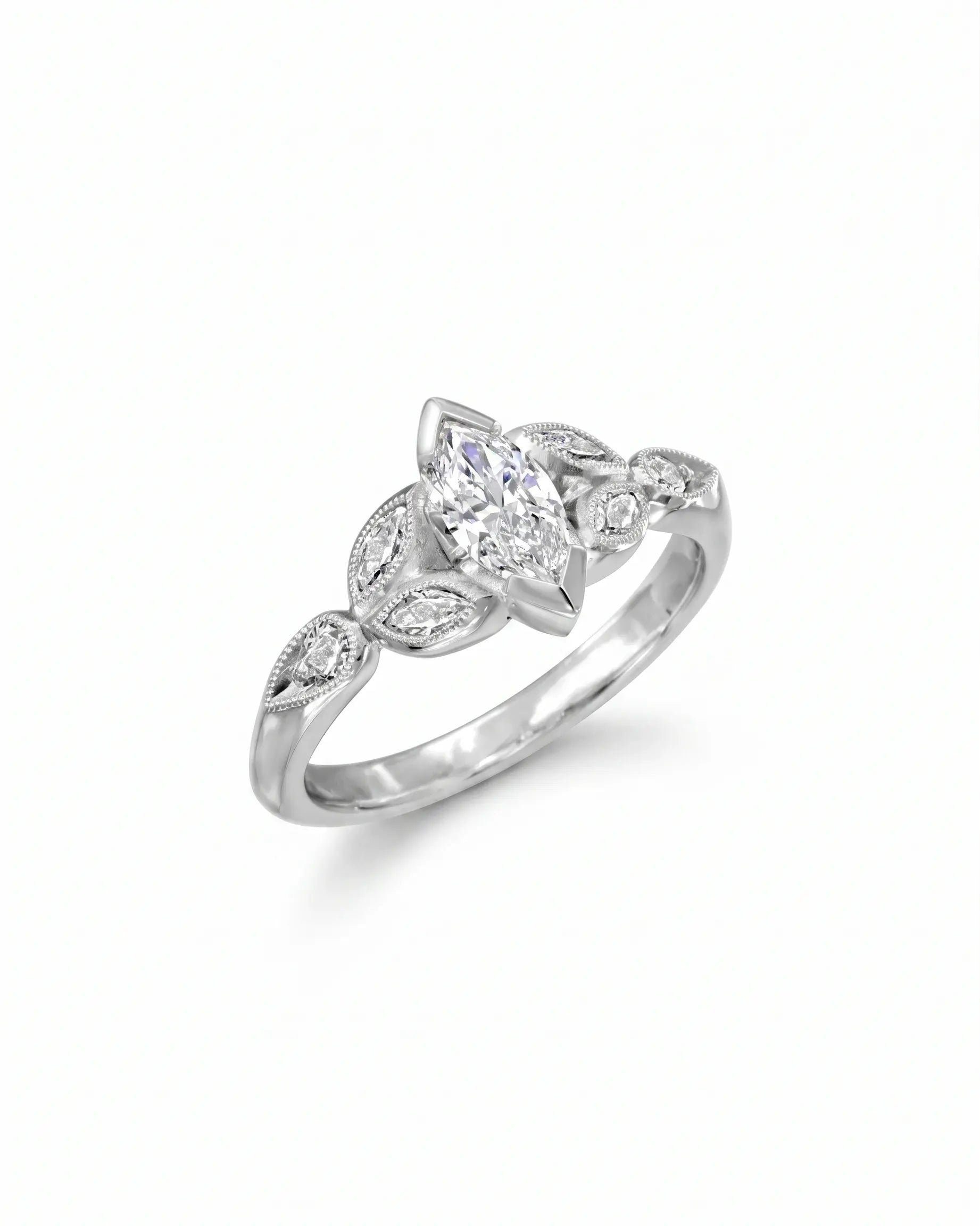White gold engagement ring with a marquise cut diamond and vintage leaf design.