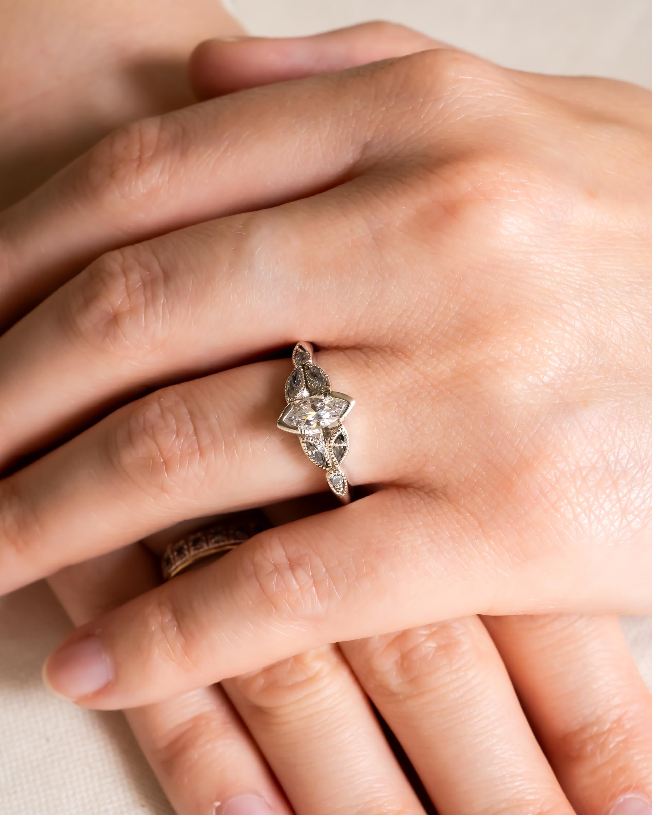 Silver marquise cut vintage engagement ring with clear gemstones.