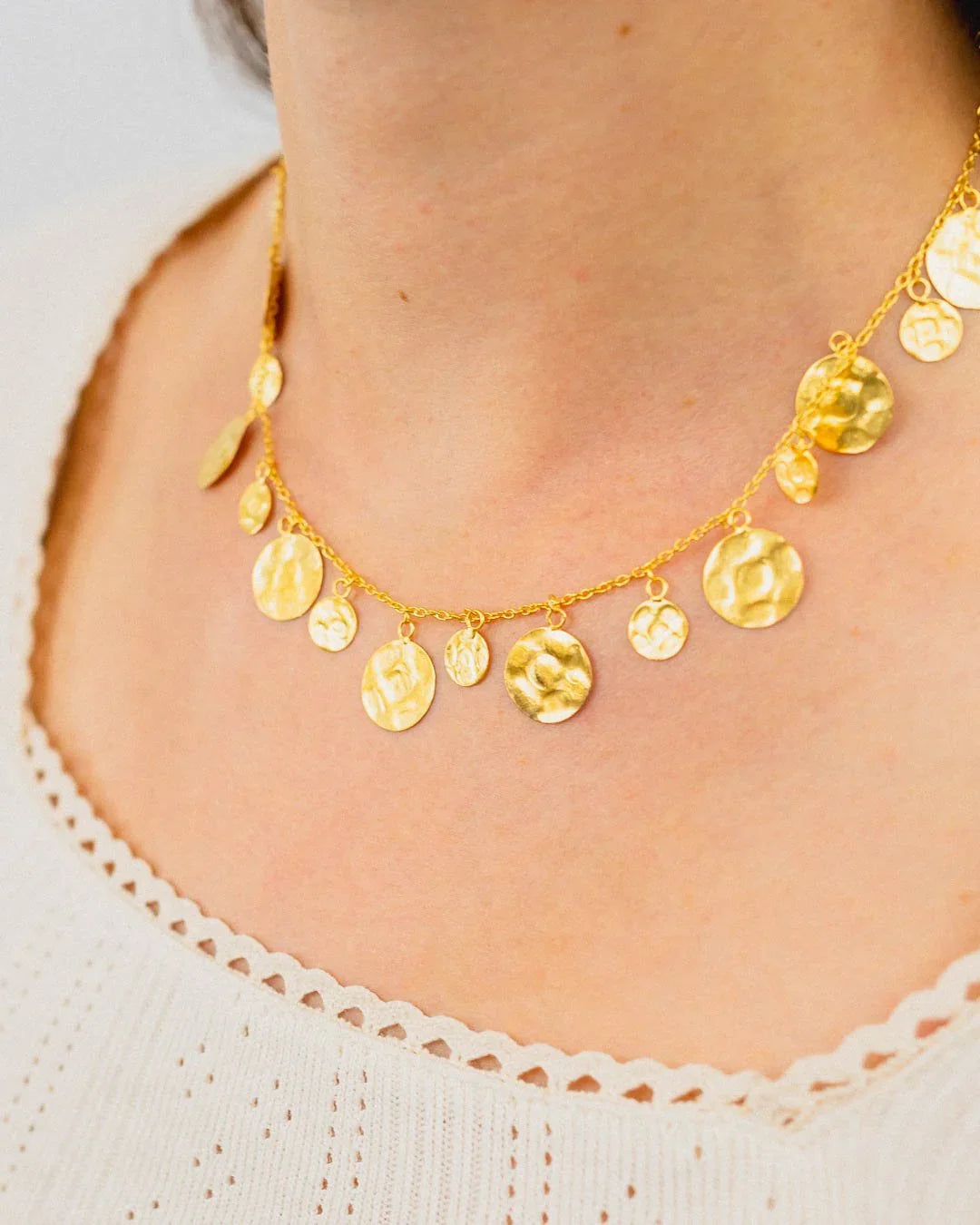 hammered yellow gold round disc necklace with organic textured finish on model