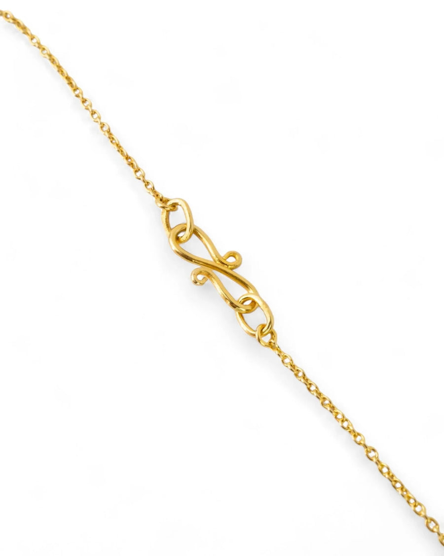 Handmade yellow gold necklace with a hammered finish and intricate clasp on white background
