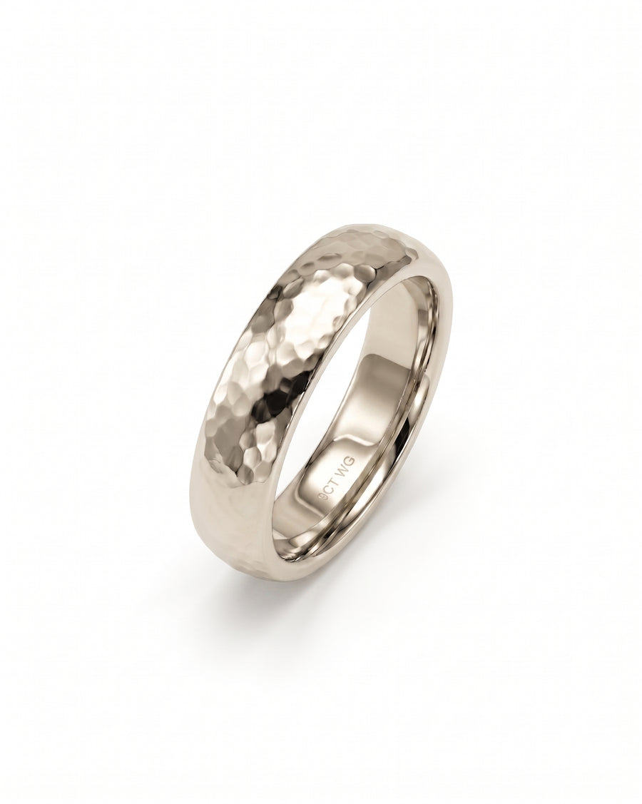 Silver-toned hammered court wedding ring with a polished interior band on a white background.