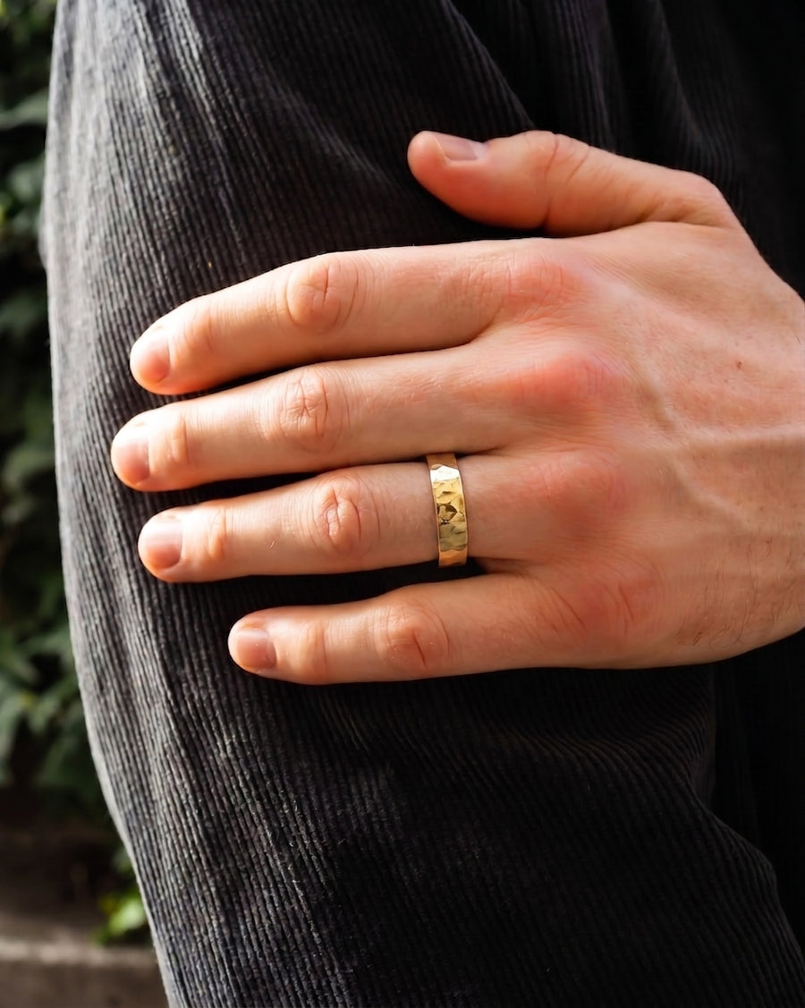 Gold hammered wedding ring on a man's finger.