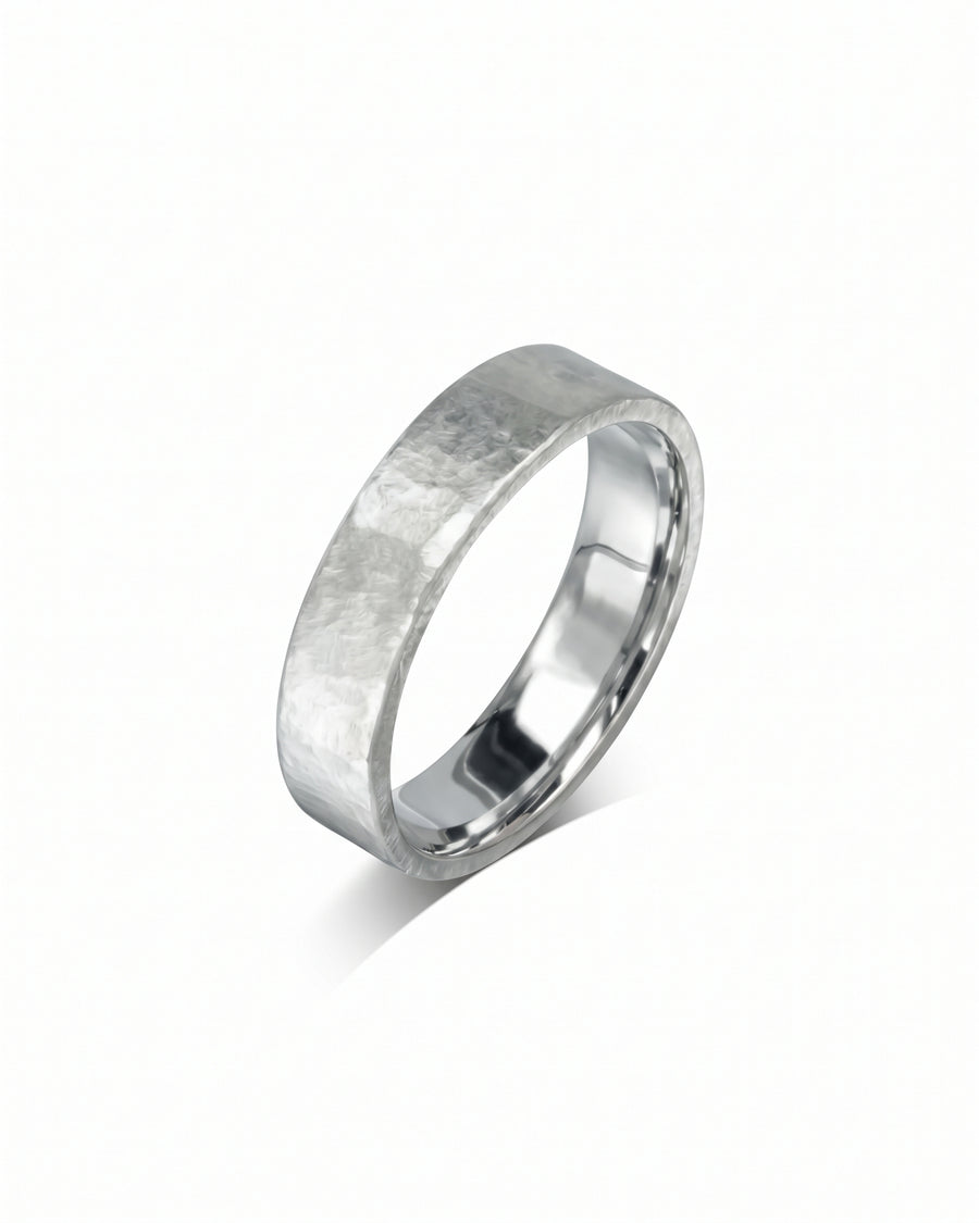 Silver wedding ring with a rough hammered texture and a polished inner band on a white background.