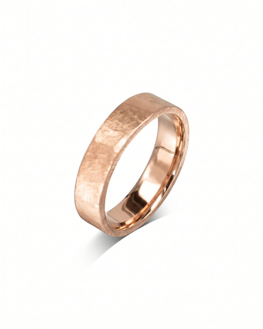 Rose gold wedding ring with a textured, hammered finish and a polished inner band.