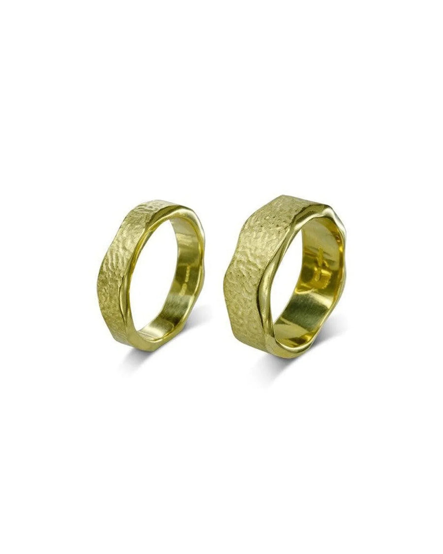Hammered textured gold wedding bands with organic, rugged finish on white background