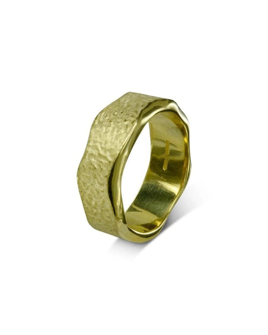 Hammered textured gold wedding band with organic, rugged shape on white background