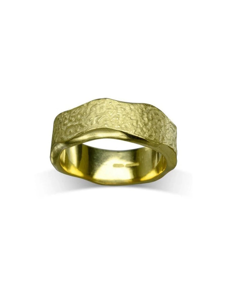 Handcrafted gold wedding band with hammered texture and organic, wavy edge