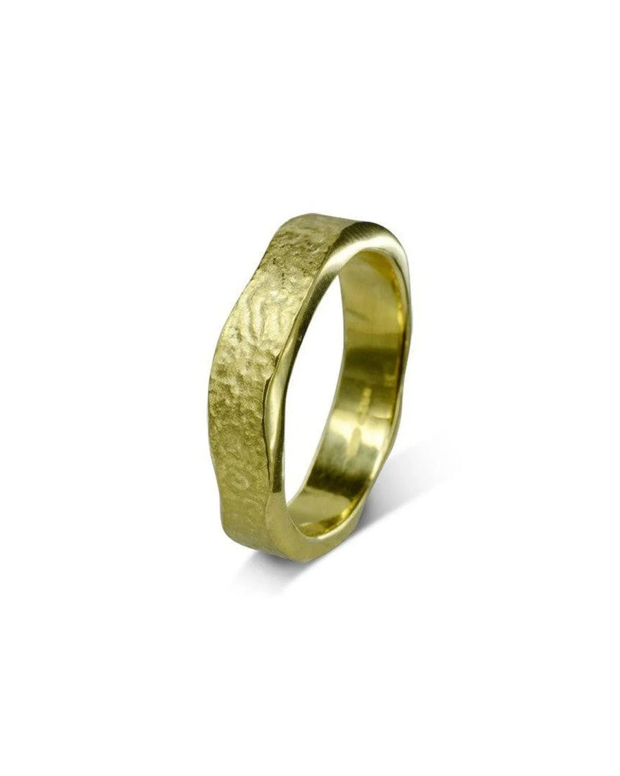 Hammered textured yellow gold wedding ring with organic, rugged finish on white background.