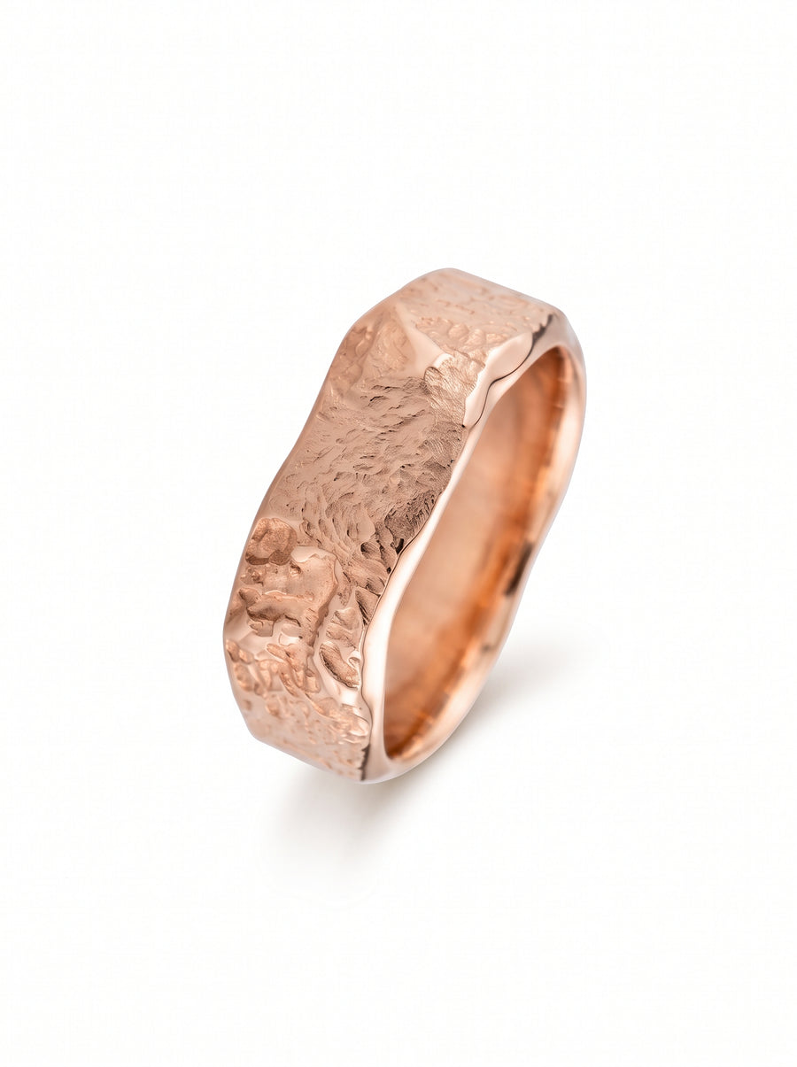 Rose gold wedding band featuring a textured, hammered finish on the outer edges and a smooth interior.