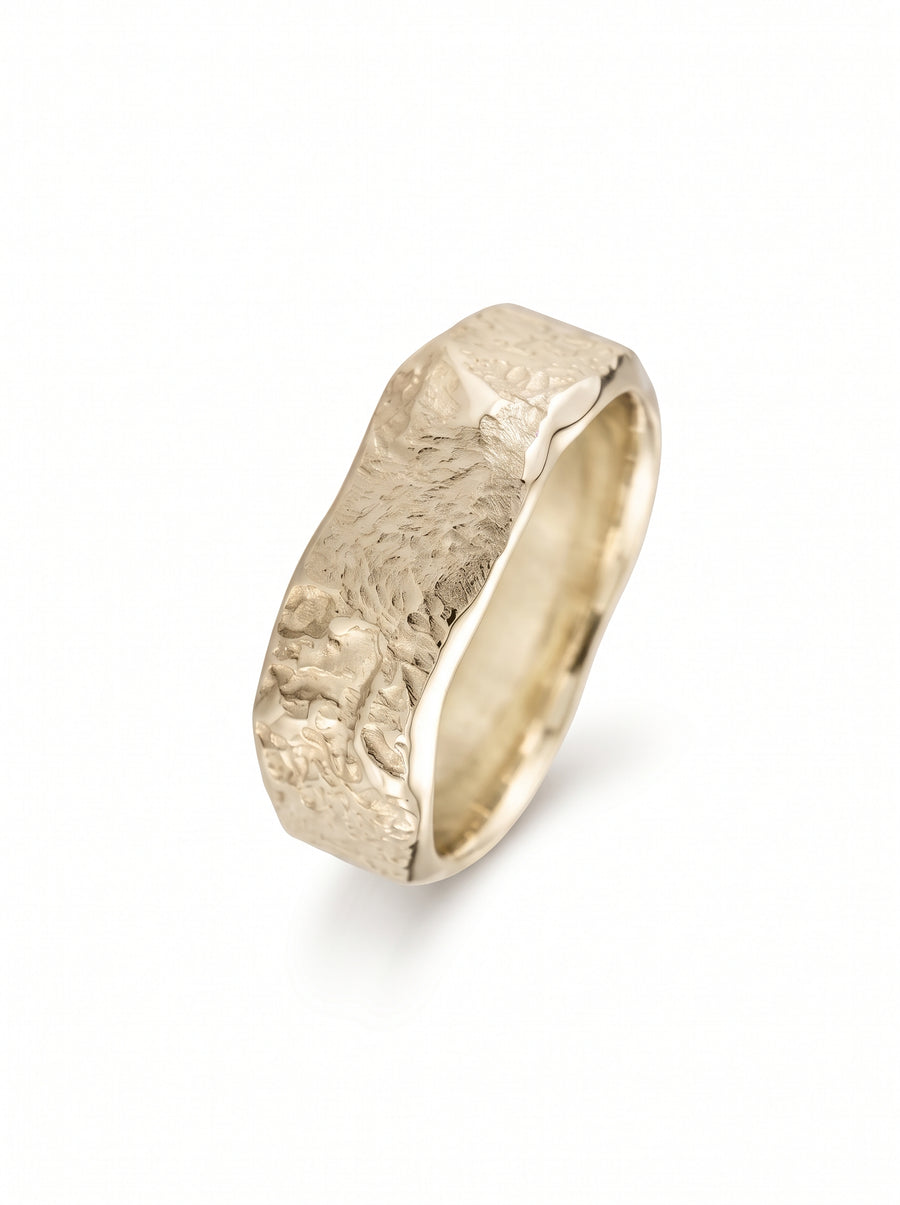 Yellow gold wedding band featuring a textured, hammered finish on the outer surface against a white background.