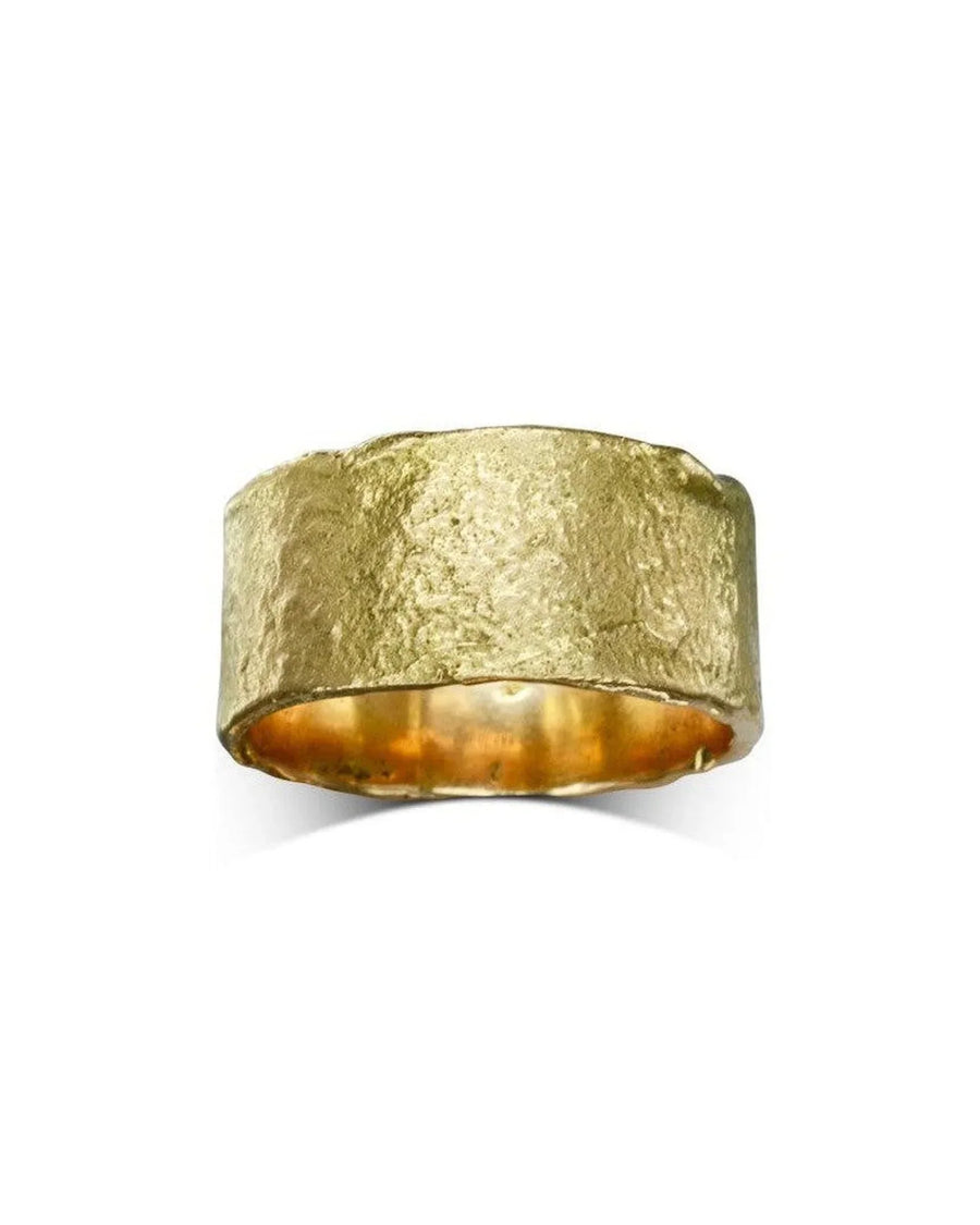 Wide gold wedding band with organic reticulated texture on a white background
