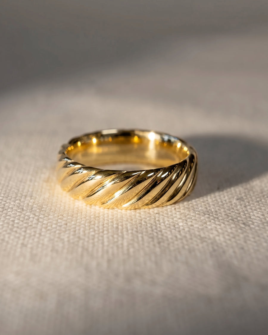 4mm twisted wedding band in 9ct yellow gold with a polished, textured finish on a neutral fabric surface.