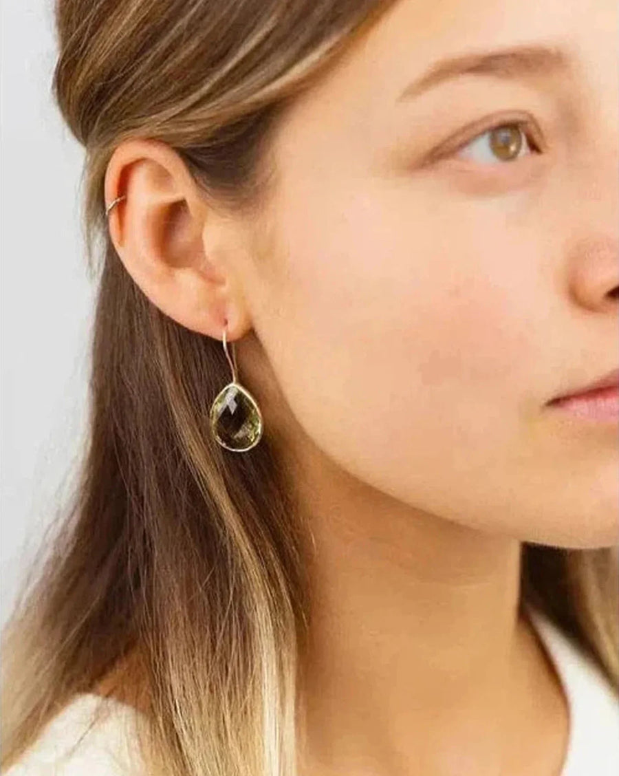 Woman wearing handmade green rock crystal drop earring with minimalist gold hook