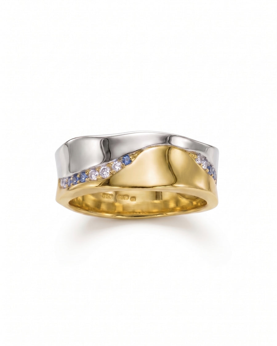 Mixed metal wavy eternity ring with diamonds and sapphires.