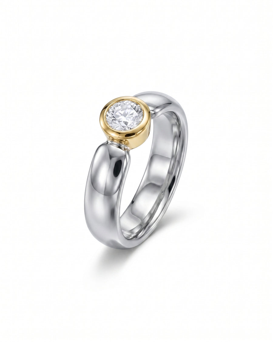 Mixed metal modern ring with a bezel-set round diamond.
