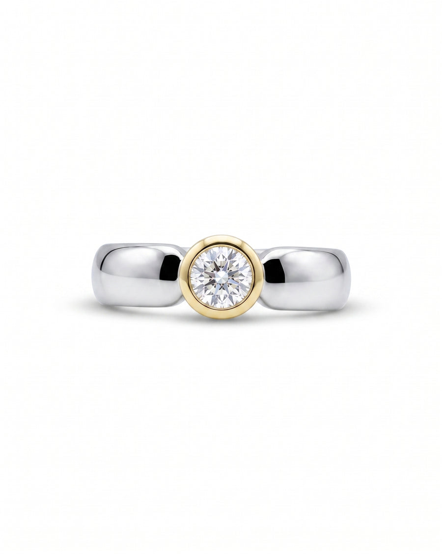 Mixed metal modern diamond ring with a round bezel-set diamond.