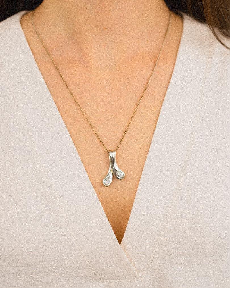 Elegant diamond pendant necklace with organic design on a woman's neck