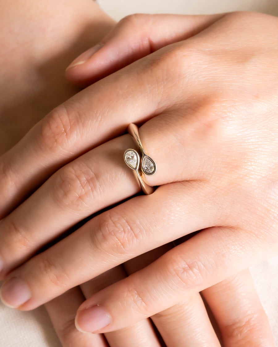 Gold Moi et Toi ring with two pear-shaped diamonds on a hand.