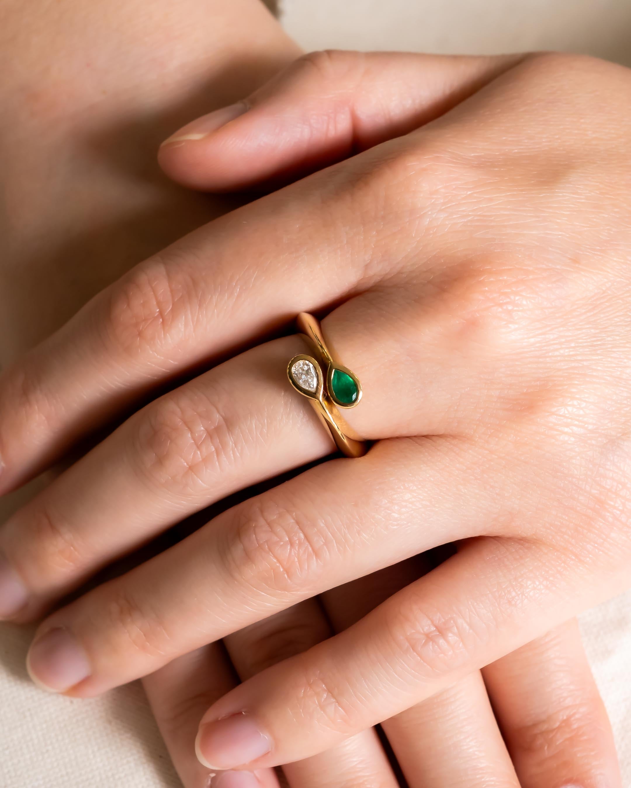 9ct yellow gold ring with pear-shaped diamond and emerald gemstones.