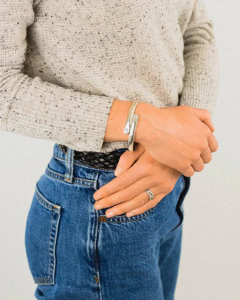 Handmade silver diamond cuff bangle worn on wrist, paired with casual sweater and jeans